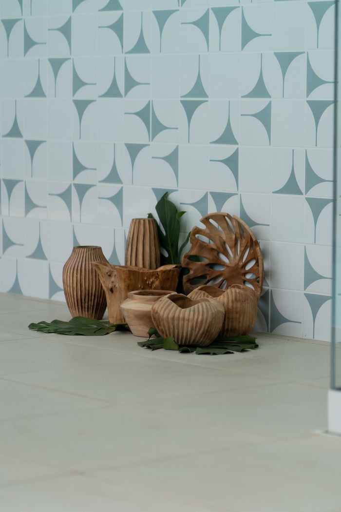 Stylish wooden decor set against modern geometric tiled wall, perfect for home design inspiration.