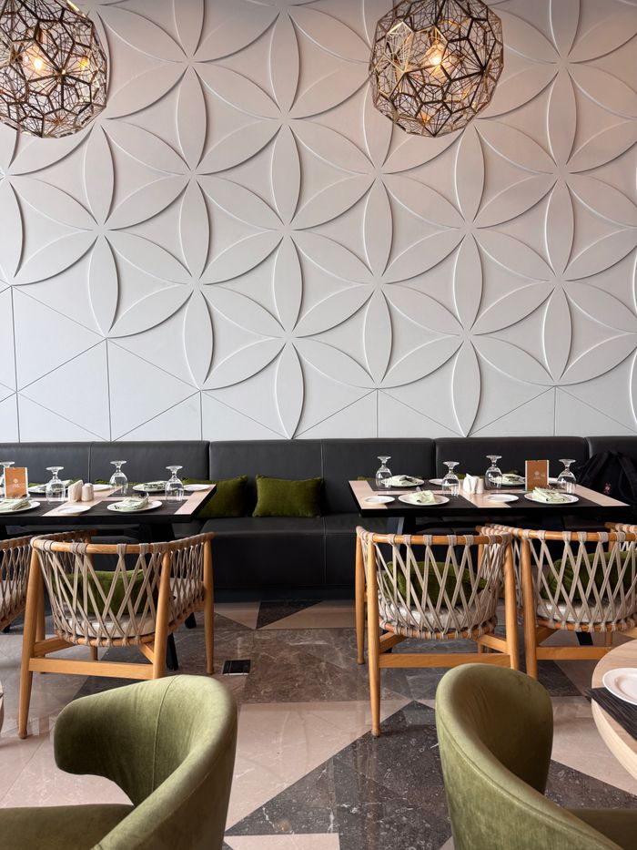 Services Chic cafe setup with unique chairs and geometric wall panels.