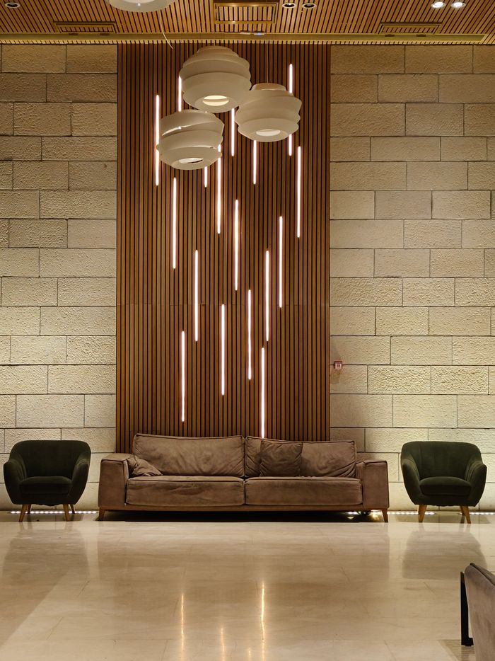 Services Contemporary living room featuring a cozy sofa, chic armchairs, and modern lighting design.