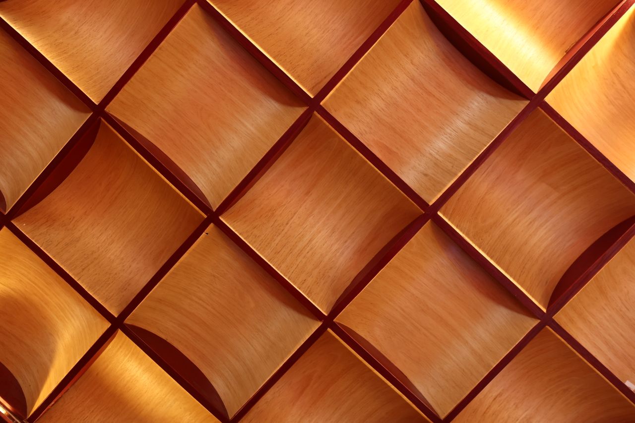 Services Close-up of a geometric wooden texture displaying light and shadows with a modern design.